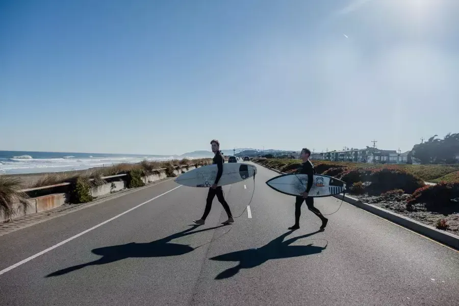 尼克Whittlesey holding a surfboard on the Great Highway.