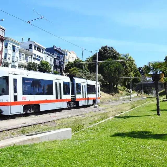 Un train de voyageurs MUNI circule sur une voie ferrée à San Francisco.